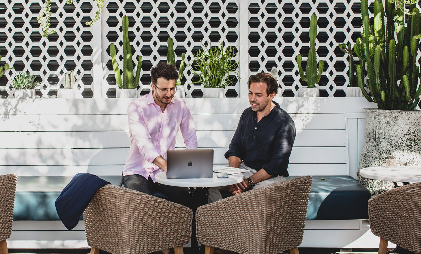Two people planning a venue campaign on a laptop